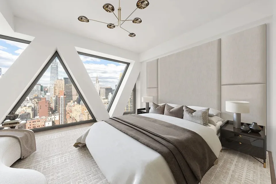 Penthouse bedroom with an upholstered wall and triangular lattice windows over the city at Midtown Luxury Residences, 30 East 31 Street, New York City, interior design by Alexandra Peck Design