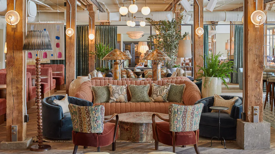 Club Cecconi’s lounge with a curved terracotta sofa, velvet armchairs and timber columns at Soho House Nashville, Nashville, Tennessee, interior design led by Alexandra Peck