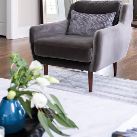 Detail: gray velvet armchair and white tulips in the living room at Durham Transitional, Durham, North Carolina, interior design by Alexandra Peck Design