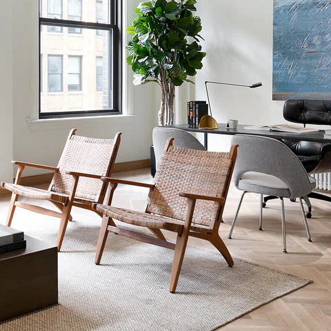 Detail: woven lounge chairs, a fiddle-leaf fig and the desk beneath steel-framed windows in the executive office at Flatiron Workplace, 3 East 28th Street, New York City, interior design by Alexandra Peck Design