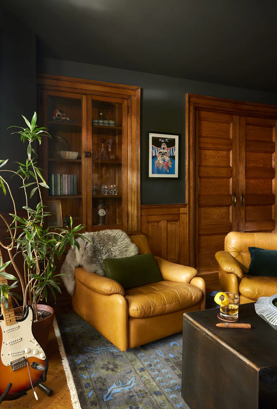 Vintage 1960s cognac leather armchairs and a hot-rolled steel coffee table in the moss-green study at the Prospect Heights Brownstone, Brooklyn, New York, interior design by Alexandra Peck Design