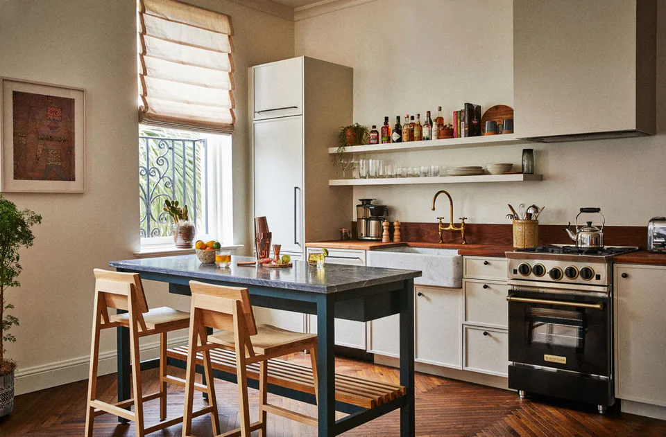 Kitchen island with a walnut top and wooden stools, open shelves and a black range at The Pinch Hotel, Charleston, South Carolina, interior design by Alexandra Peck Design