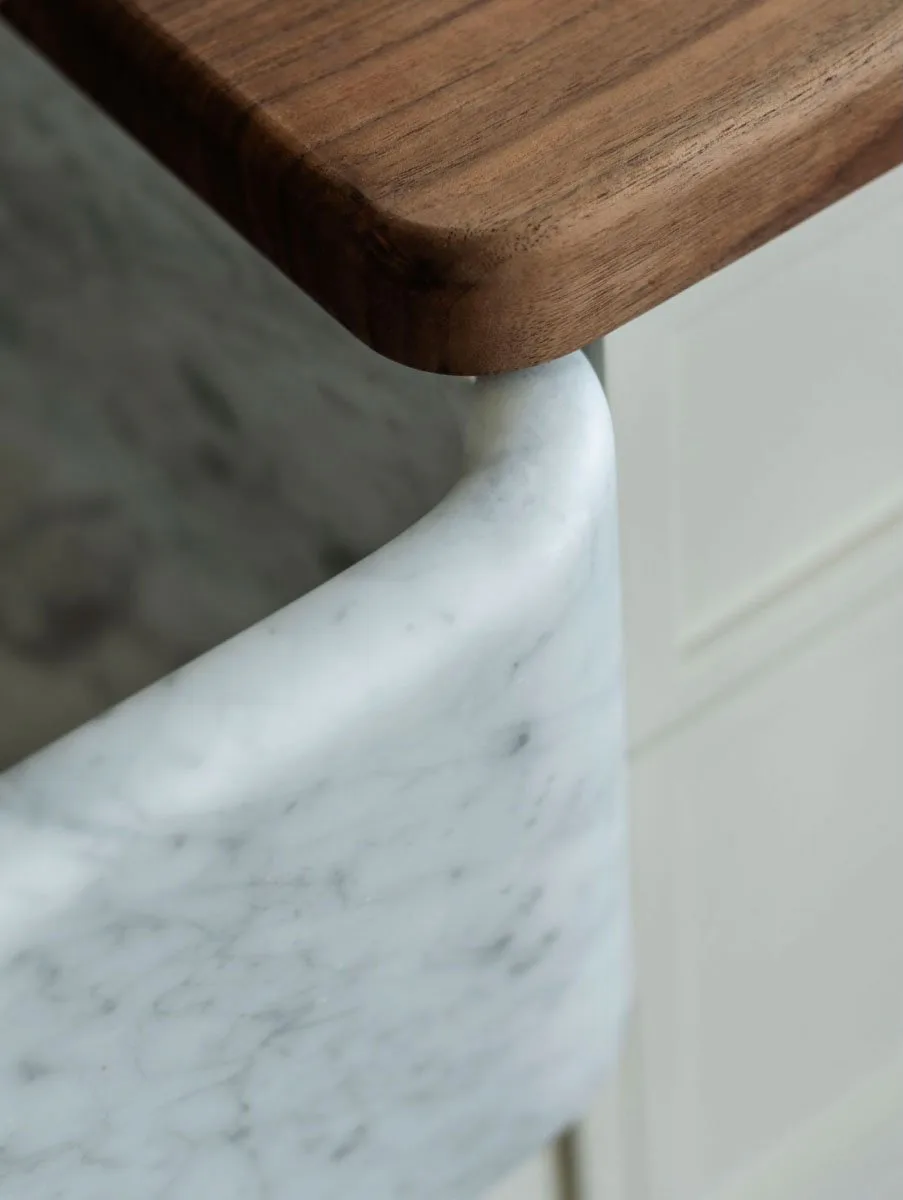 Corner of a Carrara marble farmhouse sink beneath a walnut countertop at The Pinch Hotel, Charleston, South Carolina, interior design by Alexandra Peck Design